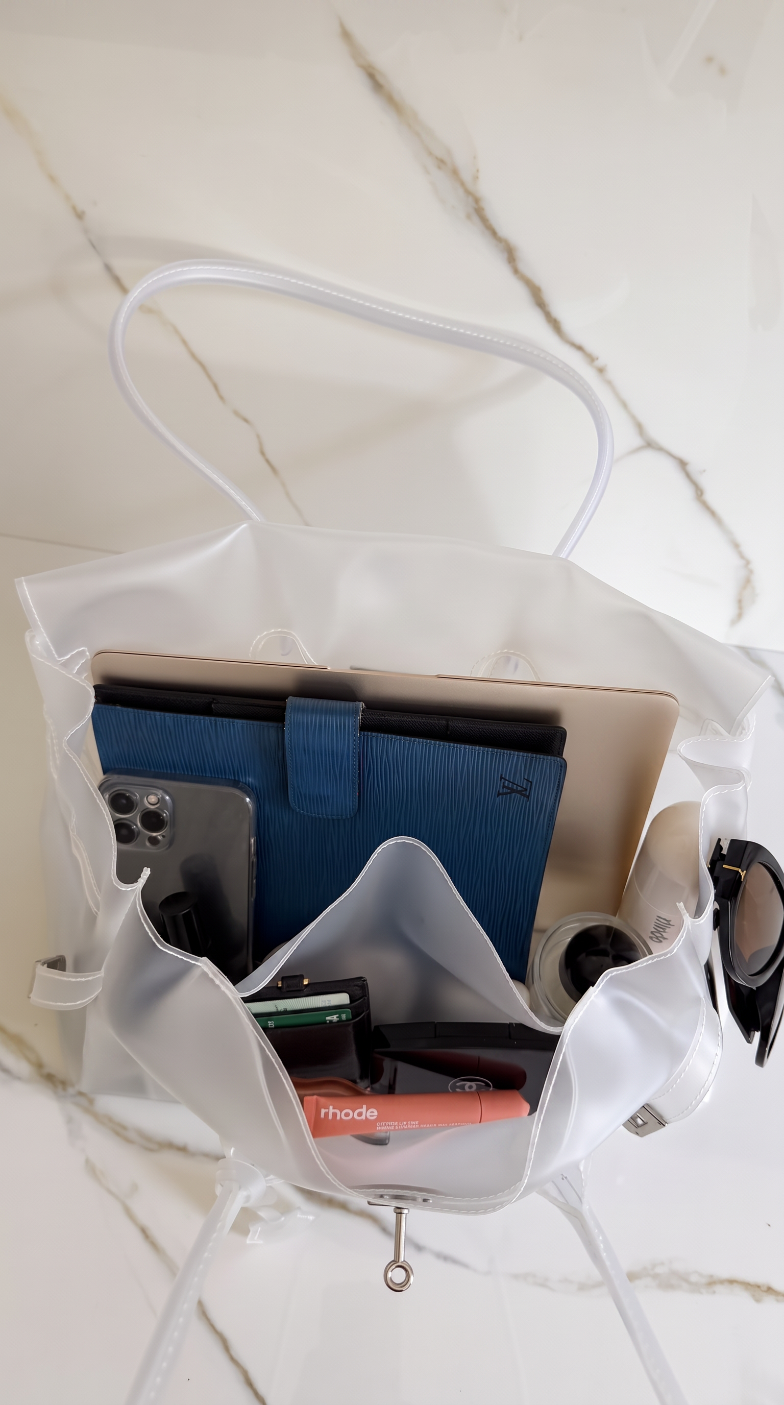 Sac Jelly Firkin ouvert vu du dessus, rempli d'un ordinateur portable et des essentiels du quotidien